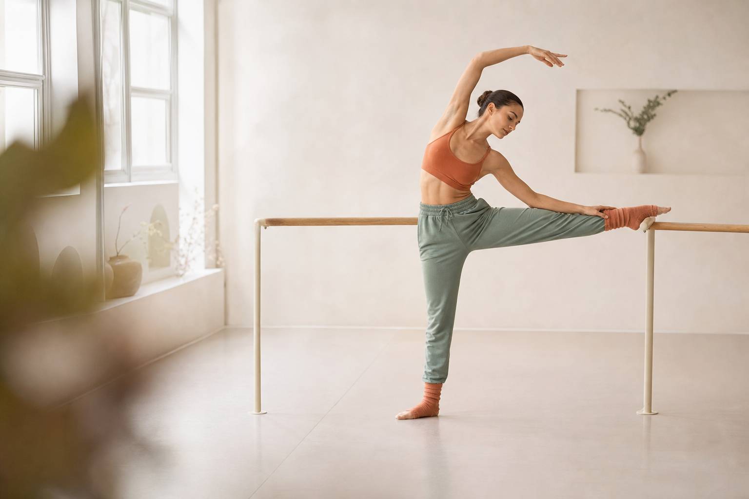 Personne a la barre de danse jambe levee sur la barre etirement lateral