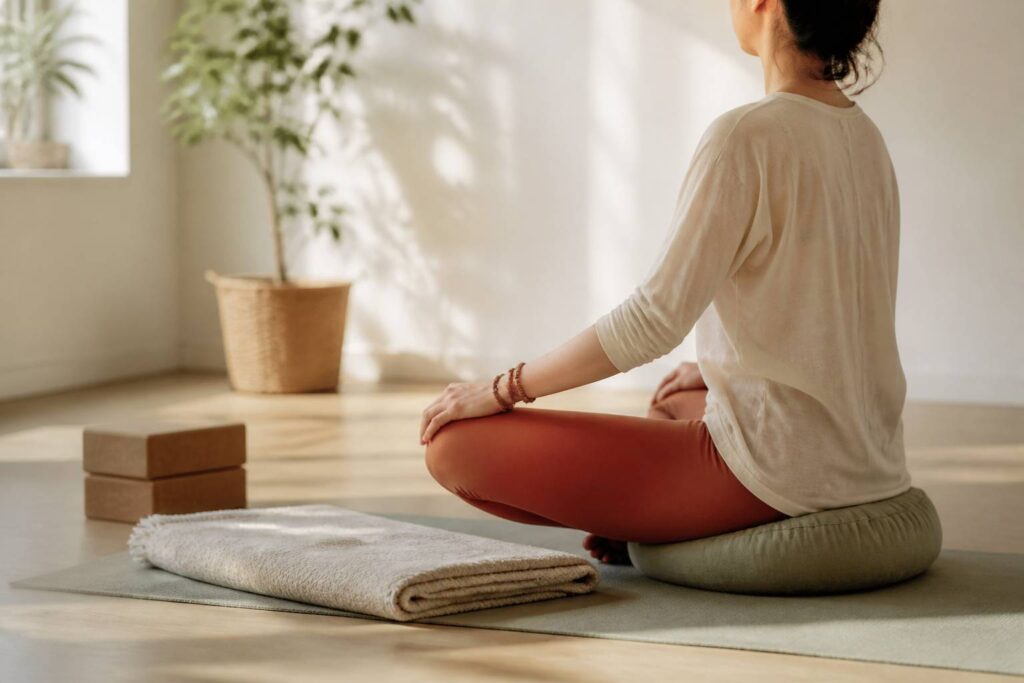 Studio de yoga lumineux avec une personne méditant sur un coussin